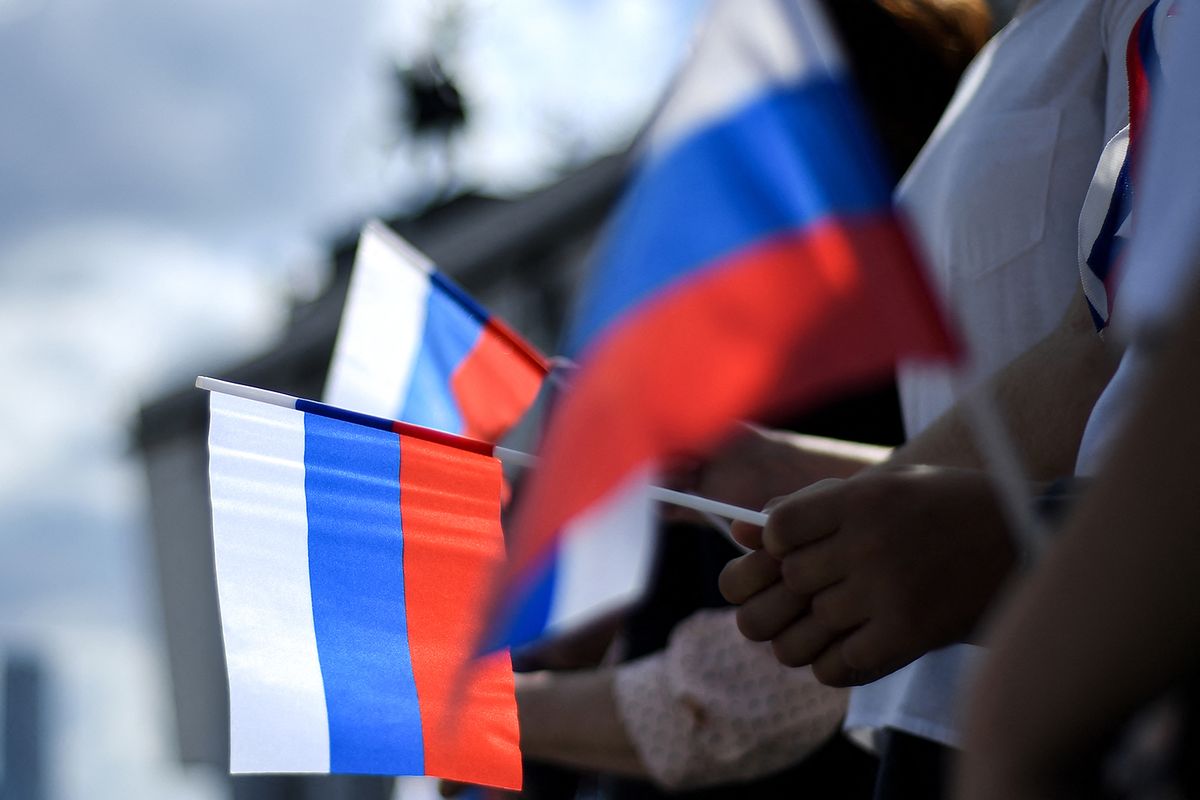 People hold Russian national flags during a celebration ceremony of the National Flag Day at Poklonnaya Hill in Moscow on August 22, 2020. Russia marks the 29th anniversary of the abortive 1991 coup against then Soviet president Mikhail Gorbachev.  August 22, 1991, was declared as Russia's Flag Day when Russia's flag was raised atop the Russian White House instead of the Soviet one was declared as Russia's Flag Day. (Photo by Kirill KUDRYAVTSEV / AFP)