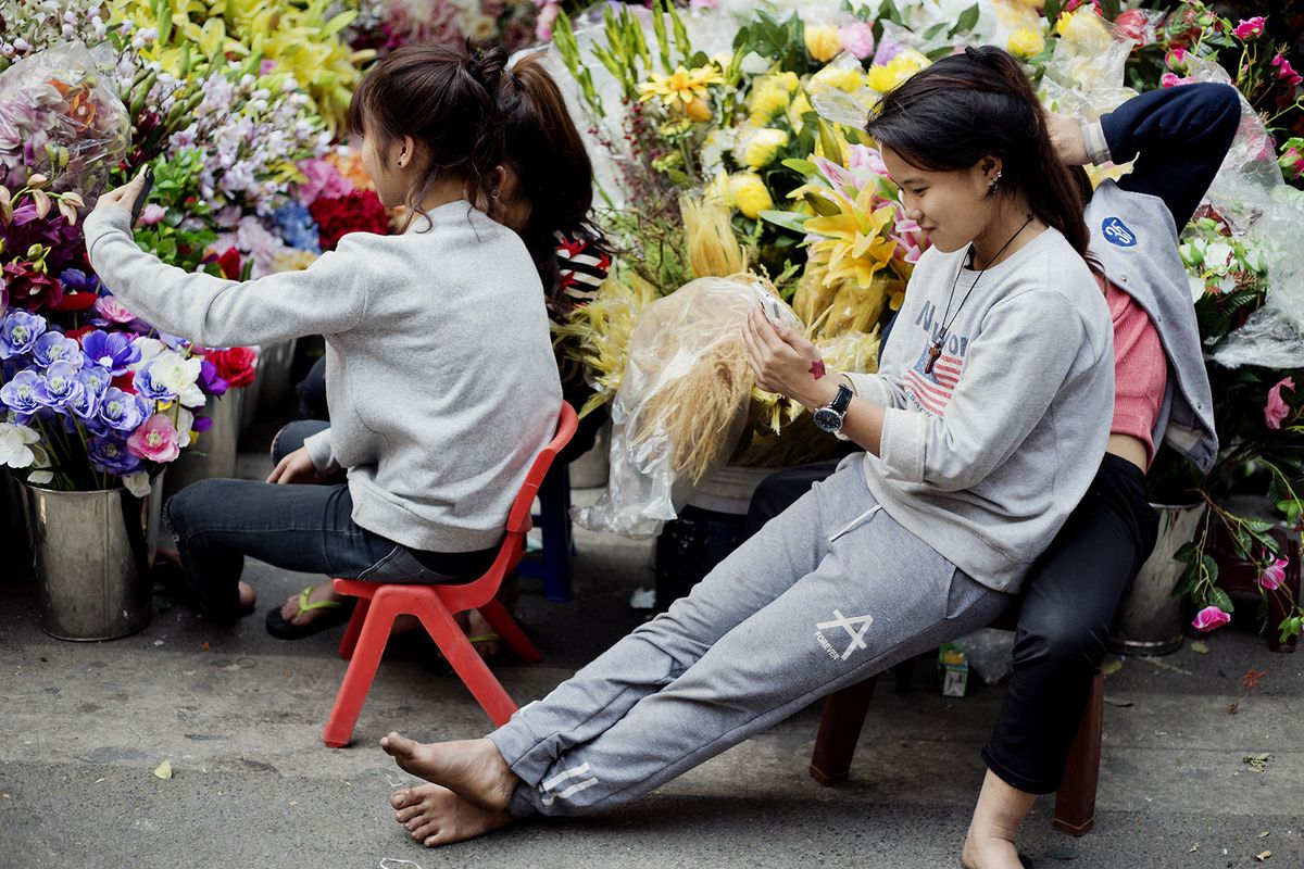 Shopping Ahead Of Tet
A vendor uses a smart phone at a street market stall selling plastic flowers ahead of the Vietnamese Lunar New Year holiday, known as Tet, in Hanoi, Vietnam, on Tuesday, Jan. 24, 2017. Vietnam has been enjoying a foreign investor-led economic boom for years as it transformed from mainly an exporter of agricultural commodities, such as rice and coffee, to a Southeast Asian manufacturing hub. Photographer: Maika Elan/Bloomberg via Getty Images