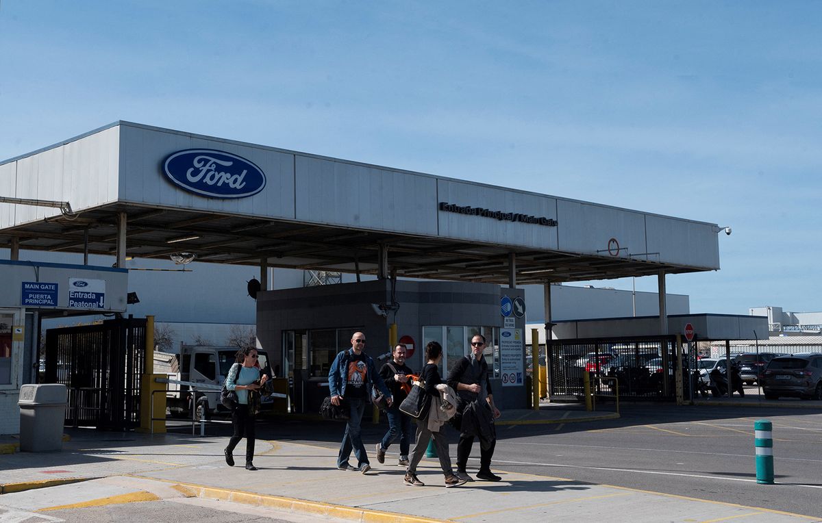 Workers leave the Ford factory in Almussafes near Valencia, on March 10, 2023, after the US carmaker announced it will cut around 1,100 jobs at this factory as it reorganises its operations in Europe. The cuts follow the announcement last month by Ford of 3,800 job cuts elsewhere in Europe, including 2,300 positions in Germany and 1,300 in Britain. Those cuts hit product development and administrative functions, not manufacturing positions, and represented about 10 percent of its European staff. Ford said the cuts aimed to create "a leaner, more competitive cost structure" for the company. (Photo by JOSE JORDAN / AFP)