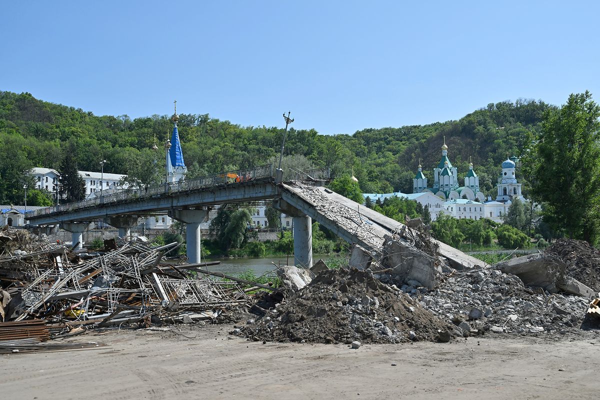 Workers clean debris of the destroyed bridge next to the Svyatogirsk Orthodox Christian Monastery in the town of Svyatogirsk, Donetsk region on June 22, 2023, amid the Russian invasion of Ukraine.
