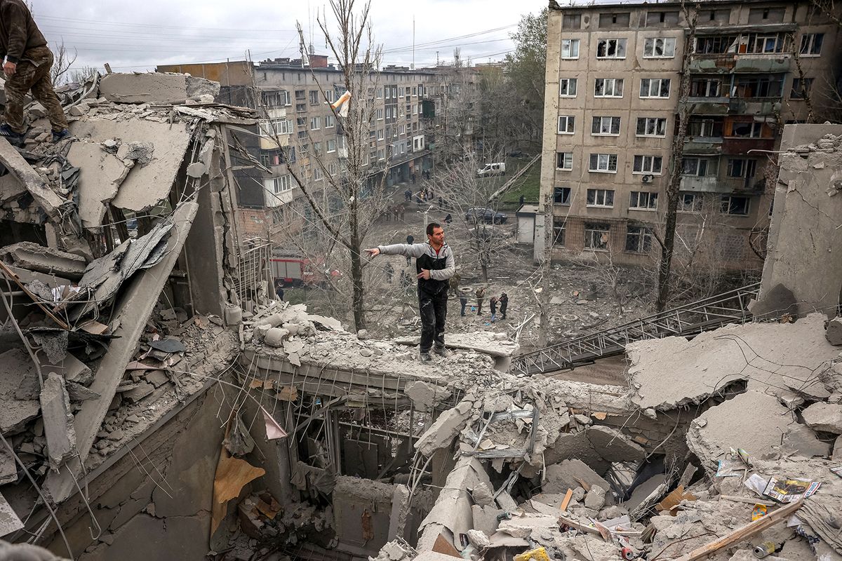 A volunteer gesticulates on top of a partially destroyed residenial building after a shelling in Sloviansk, Donetsk region on April 14, 2023, amid the Russian invasion of Ukraine. A Russian shelling of a residential building in the eastern Ukrainian city of Sloviansk killed at least five people on April 14, the local governor said, warning that others could be buried in the rubble. (Photo by ANATOLII STEPANOV / AFP)