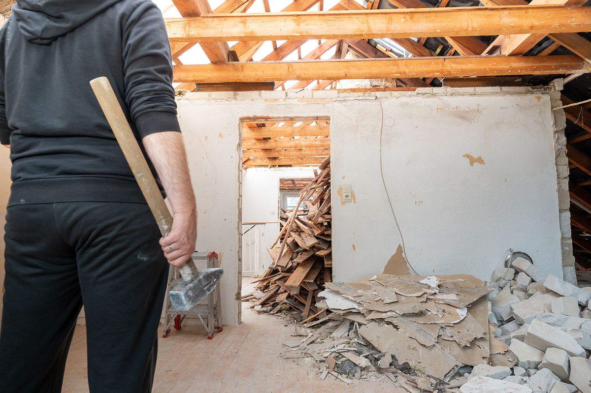 Construction,Worker,With,A,Sledge,Hammer,After,Demolishing,A,Brick
Construction worker with a sledge hammer after demolishing  a brick wall in a private home.