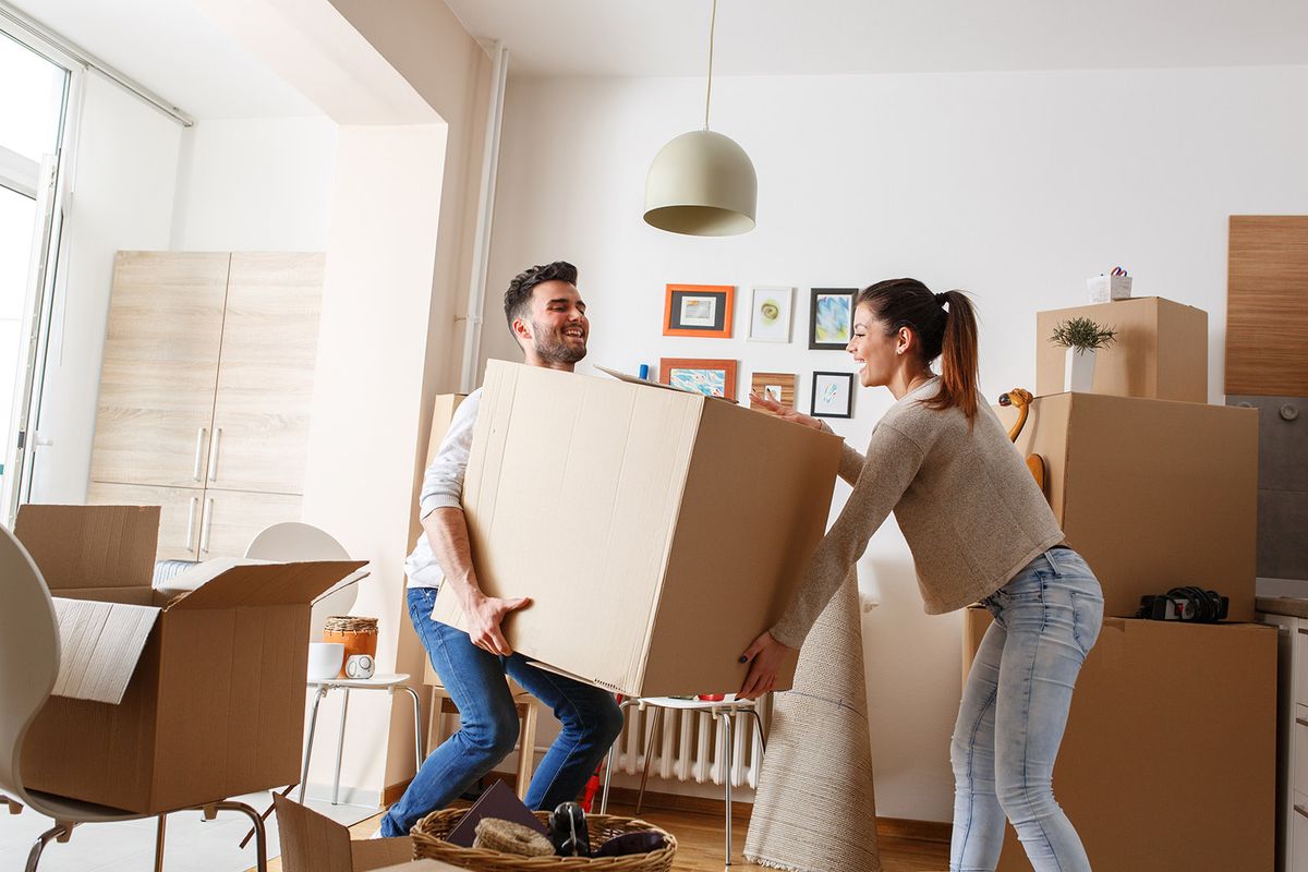 Young,Couple,Carrying,Big,Cardboard,Box,At,New,Home.moving,House.
Young couple carrying big cardboard box at new home.Moving house.