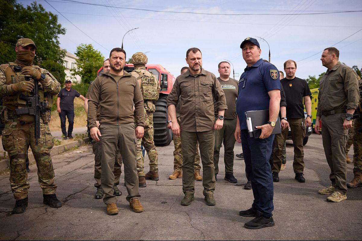 This handout photograph taken and released by Ukrainian Presidential press-service on June 8, 2023, shows Ukraine's President Volodymyr Zelensky (2ndL) visiting local residents evacuated from a flooded area in Kherson, following damages sustained at Kakhovka hydroelectric power plant dam. The dam was breached on June 7, 2023, forcing thousands to flee their homes as water surged into the Dnipro River, flooding dozens of villages and parts of the regional capital Kherson and sparking fears of a humanitarian disaster. (Photo by Handout / UKRAINIAN PRESIDENTIAL PRESS SERVICE / AFP) / -----EDITORS NOTE --- RESTRICTED TO EDITORIAL USE - MANDATORY CREDIT "AFP PHOTO / HANDOUT/UKRAINIAN PRESIDENTIAL PRESS SERVICE " - NO MARKETING - NO ADVERTISING CAMPAIGNS - DISTRIBUTED AS A SERVICE TO CLIENTS