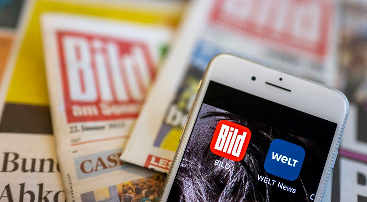 Apps of the newspapers "Bild" and "Die Welt
ILLUSTRATION - 23 January 2023, Berlin: The apps of the newspapers "Bild" and "Die Welt" can be seen on the screen of a smartphone, while the paper editions of the newspapers lie on a table in the background. The Axel Springer media group wants to significantly expand its reach in the USA. In Germany, the group is working on a new structure for its media business with the flagship brands Bild and Welt. (To dpa: "Axel Springer wants to become America's biggest publisher") Photo: Monika Skolimowska/dpa (Photo by Monika Skolimowska / DPA / dpa Picture-Alliance via AFP)