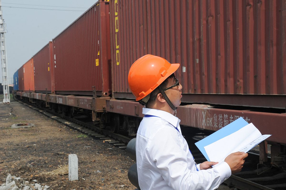 CHINA-HARBIN-EUROPE FREIGHT TRAINS-ANNIVERSARY (CN)(160618) -- HARBIN, June 18, 2016 (Xinhua) -- A logistic worker checks a Harbin-Europe freight train in Harbin, capital of northeast China's Heilongjiang Province, June 18, 2016. Cargo trains between Europe and Harbin have transported 2,526 containers, 210 million U.S. dollars worth of goods in the first year since the service was launched. The first service set off on June 13, 2015 from Harbin, reaching the German city of Hamburg via Russia and Poland.  (Xinhua/Wang Song)(mcg) (Photo by WANG SONG / XINHUA / Xinhua via AFP)