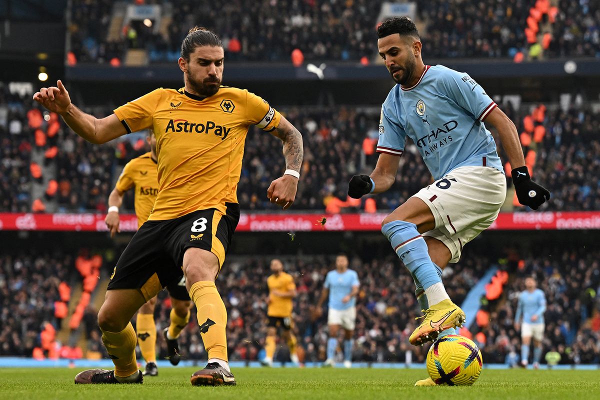 FBL-ENG-PR-MAN CITY-WOLVESManchester City's Algerian midfielder Riyad Mahrez (R) controls the ball next to Wolverhampton Wanderers' Portuguese midfielder Ruben Neves (L) during the English Premier League football match between Manchester City and Wolverhampton Wanderers  at the Etihad Stadium in Manchester, north west England, on January 22, 2023. (Photo by Paul ELLIS / AFP) / RESTRICTED TO EDITORIAL USE. No use with unauthorized audio, video, data, fixture lists, club/league logos or 'live' services. Online in-match use limited to 120 images. An additional 40 images may be used in extra time. No video emulation. Social media in-match use limited to 120 images. An additional 40 images may be used in extra time. No use in betting publications, games or single club/league/player publications. /