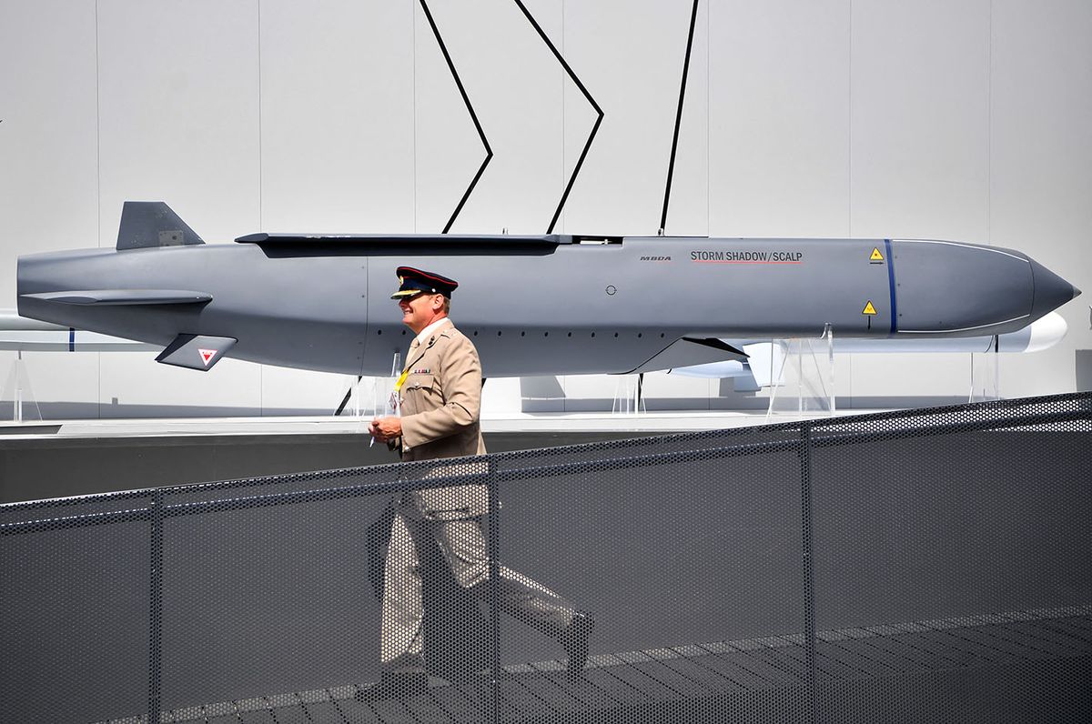 BRITAIN-AVIATION-SHOW-AEROSPACE-MANUFACTURINGA member of the military walks past a MBDA Storm Shadow/Scalp missile at the Farnborough Airshow, south west of London, on July 17, 2018. (Photo by BEN STANSALL / AFP)