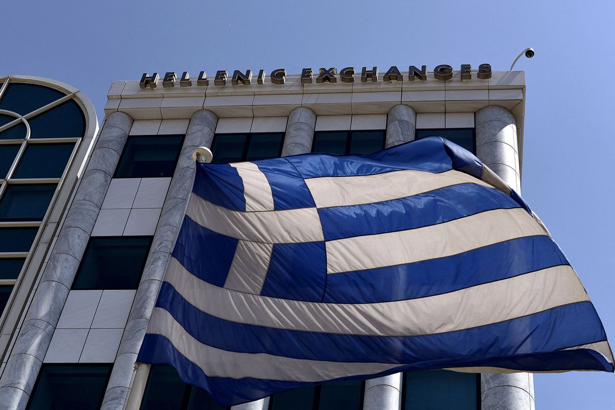 GREECE-EU-POLITICS-DEBT-STOCKSA Greek flag is pictured outside the Athens Stock Exchange in Athens on August 3, 2015. Greece's stock exchange reopened August 3 with a drop of more than 22 percent after a five-week shutdown imposed by the country's debt crisis and capital controls, with the nation's outflow-hit lenders leading the way. The ATHEX plunged to 615.72 points a few minutes after opening at 0730 GMT, down 22.82 percent from its June 26 close. AFP PHOTO / ARIS MESSINIS (Photo by Aris MESSINIS / AFP) 