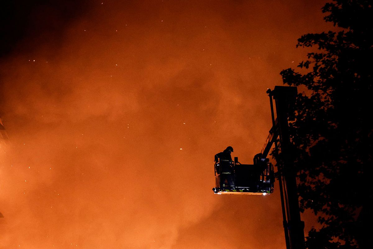 Firefighters douse the flames of a building set on fire during protests in Roubaix, northern France, on June 30, 2023, three days after a teenager was shot dead during a traffic stop in the Paris suburb of Nanterre. Protests over the fatal police shooting of a teenager rocked France for a third straight night on June 29, with cars burned, buildings vandalised and hundreds arrested in cities across the country.The nighttime unrest followed a march earlier on Thursday in memory of the 17-year-old, named Nahel, whose death has revived longstanding grievances about policing and racial profiling in France's low-income and multiethnic suburbs. (Photo by Kenzo TRIBOUILLARD / AFP)