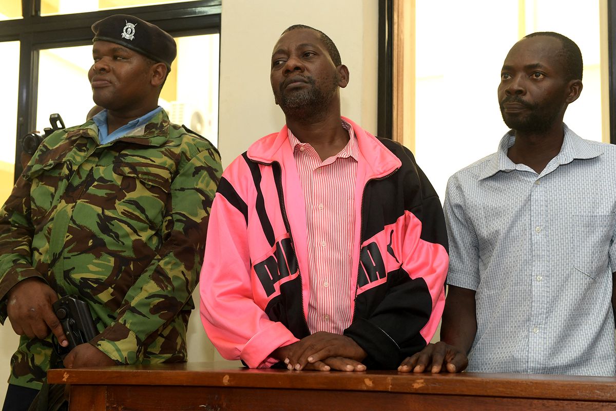 Self-proclaimed pastor Paul Nthenge Mackenzie (C), who set up the Good News International Church in 2003 and is accused of inciting cult followers to starve to death "to meet Jesus", appears in the dock with other co-accused at the court in Malindi on May 2, 2023. A Kenyan pastor appearing in court on May 2, 2023 will face terrorism charges, prosecutors said in connection with the deaths of over 100 people found buried in what has been dubbed the "Shakahola forest massacre".The deeply religious Christian-majority country has been stunned by the discovery of mass graves last month in a forest near the Indian Ocean coastal town of Malindi. (Photo by SIMON MAINA / AFP)