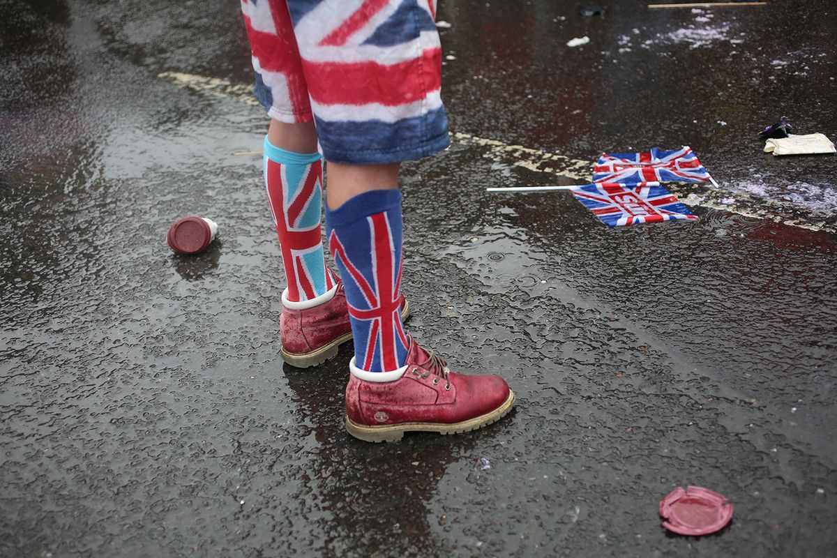 BRITAIN-ROYALS-CORONATIONA member of the public wears United Kingdom flag-themed clothes while standing in the rain on Trafalgar Square, to watch the King's Procession for the coronations of Britain's King Charles III and Britain's Queen Camilla, in London, on May 6, 2023. The set-piece coronation is the first in Britain in 70 years, and only the second in history to be televised. Charles will be the 40th reigning monarch to be crowned at the central London church since King William I in 1066. Outside the UK, he is also king of 14 other Commonwealth countries, including Australia, Canada and New Zealand. Camilla, his second wife, will be crowned queen alongside him, and be known as Queen Camilla after the ceremony. (Photo by Susannah Ireland / AFP)