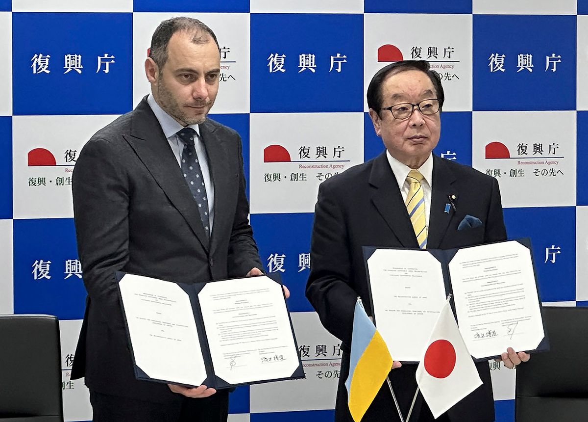 Oleksandr Kubrakov (L), Deputy Prime Minister for the Restoration of Ukraine, and Japan's Reconstruction Minister Hiromichi Watanabe (R) pose after a signing a memorandum of understanding regarding a reconstruction support initiative in Tokyo on June 19, 2023. (Photo by JIJI Press / AFP) / Japan OUT