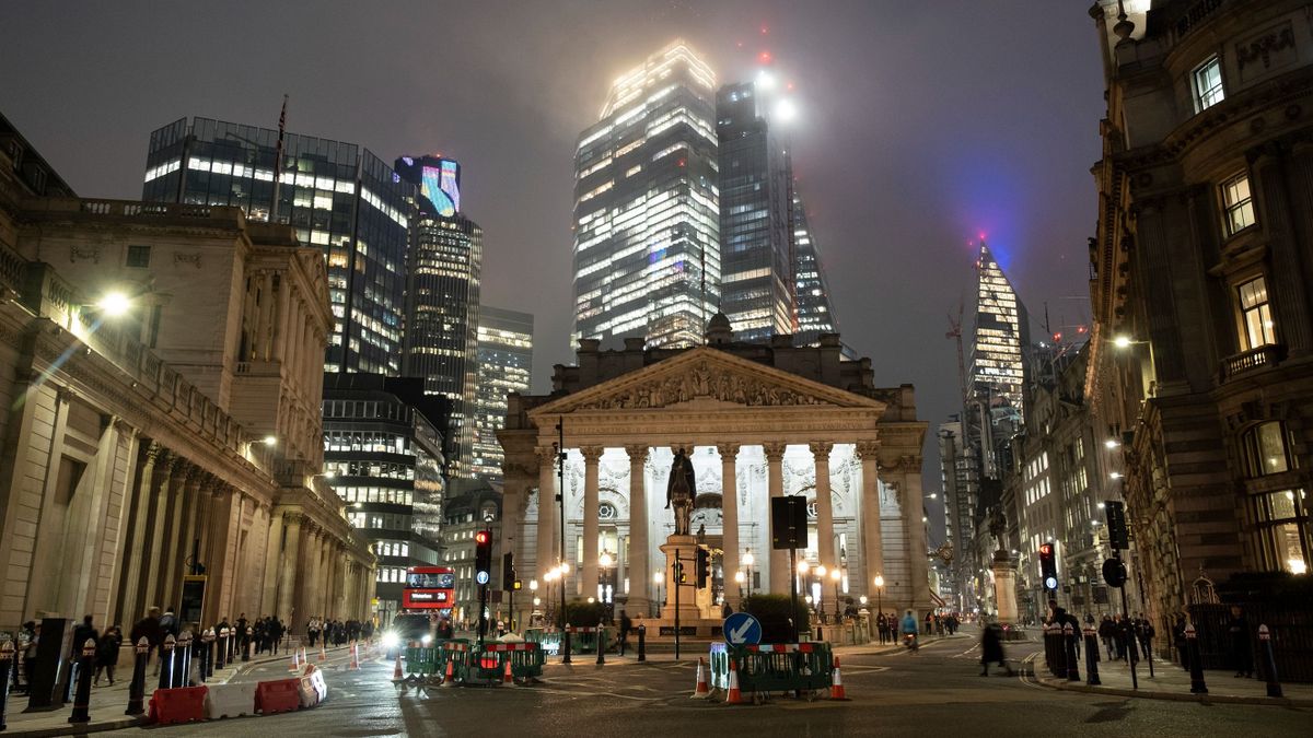 Glass skyscrapers loom through the mist at night over the Bank of England and the Royal Exchange in the City of London as the UK once again slumps into a recession on 14th November 2022 in London, United Kingdom. The City of London is a city, ceremonial county and local government district that contains the primary central business district CBD of London. The City of London is widely referred to simply as the City is also colloquially known as the Square Mile.