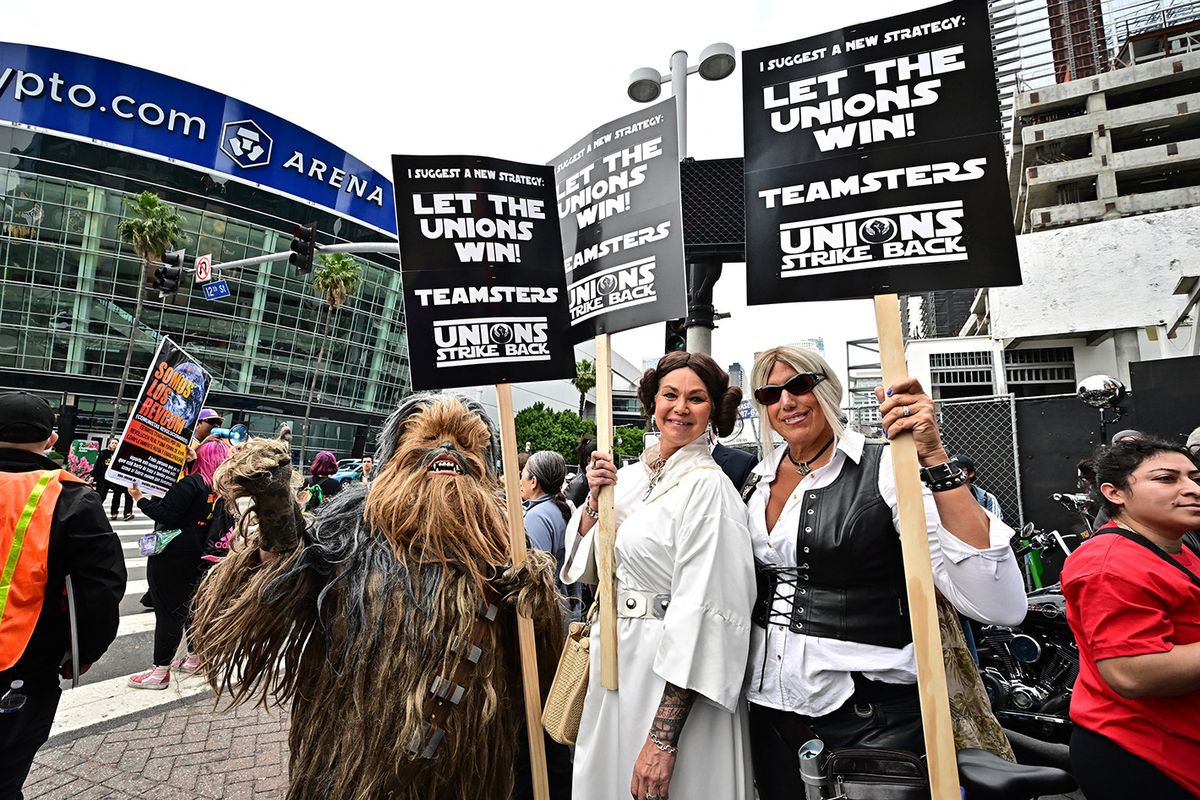 US-ENTERTAINMENT-TELEVISION-FILM-STRIKEDemonstrators hold signs while picketing during the continuing strike by the Writers Guild of America (WGA) in Los Angeles, California, on May 26, 2023. Picketing writers say they are striking for better compensation in a field that has been disrupted by the streaming industry. Writers also say they are looking for more stable working conditions and a better share of the profits generated by the rise of streaming. (Photo by Frederic J. BROWN / AFP)