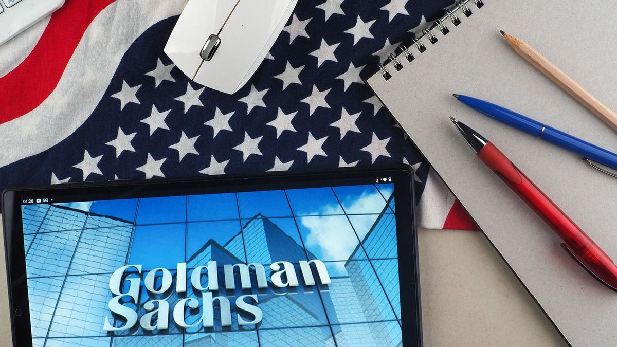 Logo illustration displayed on smartphones in Germany - 18 Feb 2023February 18, 2023, Germany: In this photo illustration, Goldman Sachs Group logo seen displayed on a tablet with a background of the US flag. LOGO SYMBOL BRAND