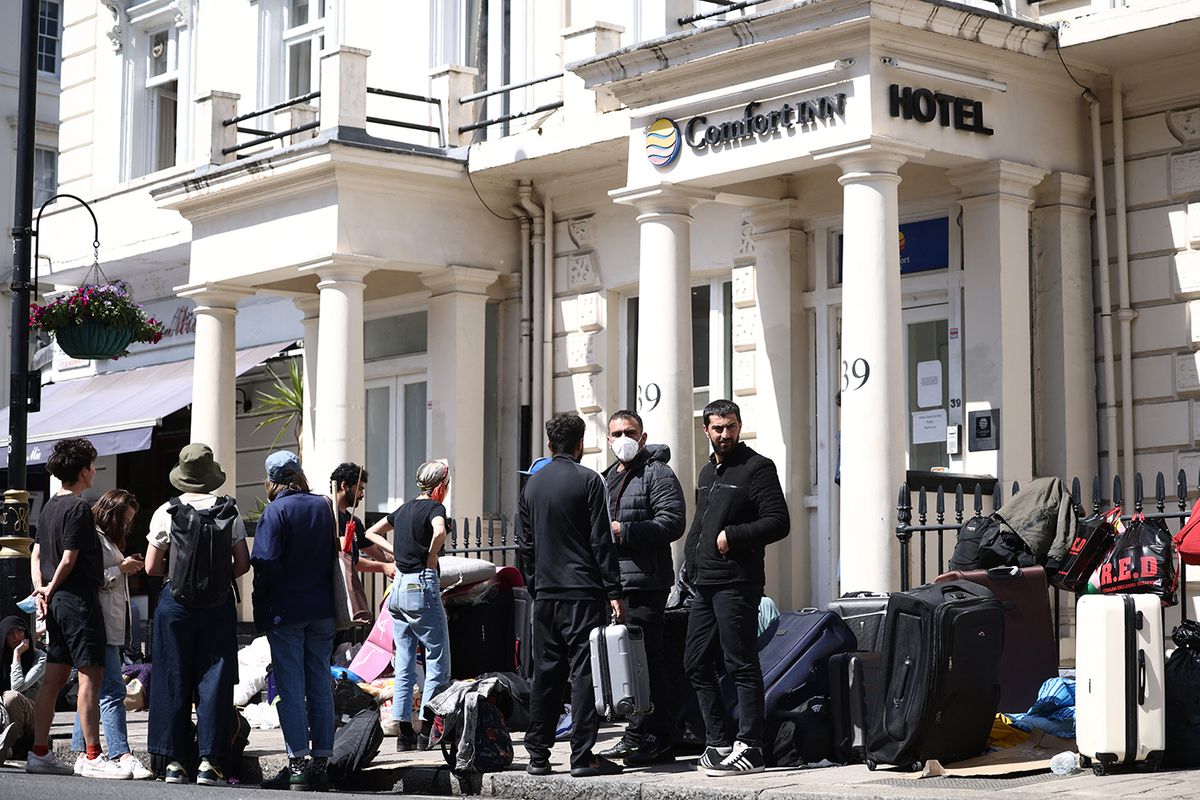 BRITAIN-EUROPE-MIGRANTSA group of migrants with their luggage, stage a protest outside their accomodation in west London on June 2, 2023, as they complain about living conditions. (Photo by HENRY NICHOLLS / AFP)