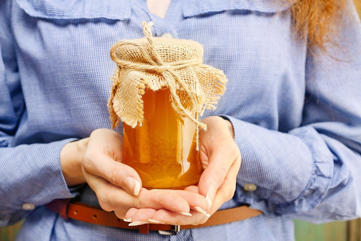 Woman,Holding,Glass,Jar,Of,Honey