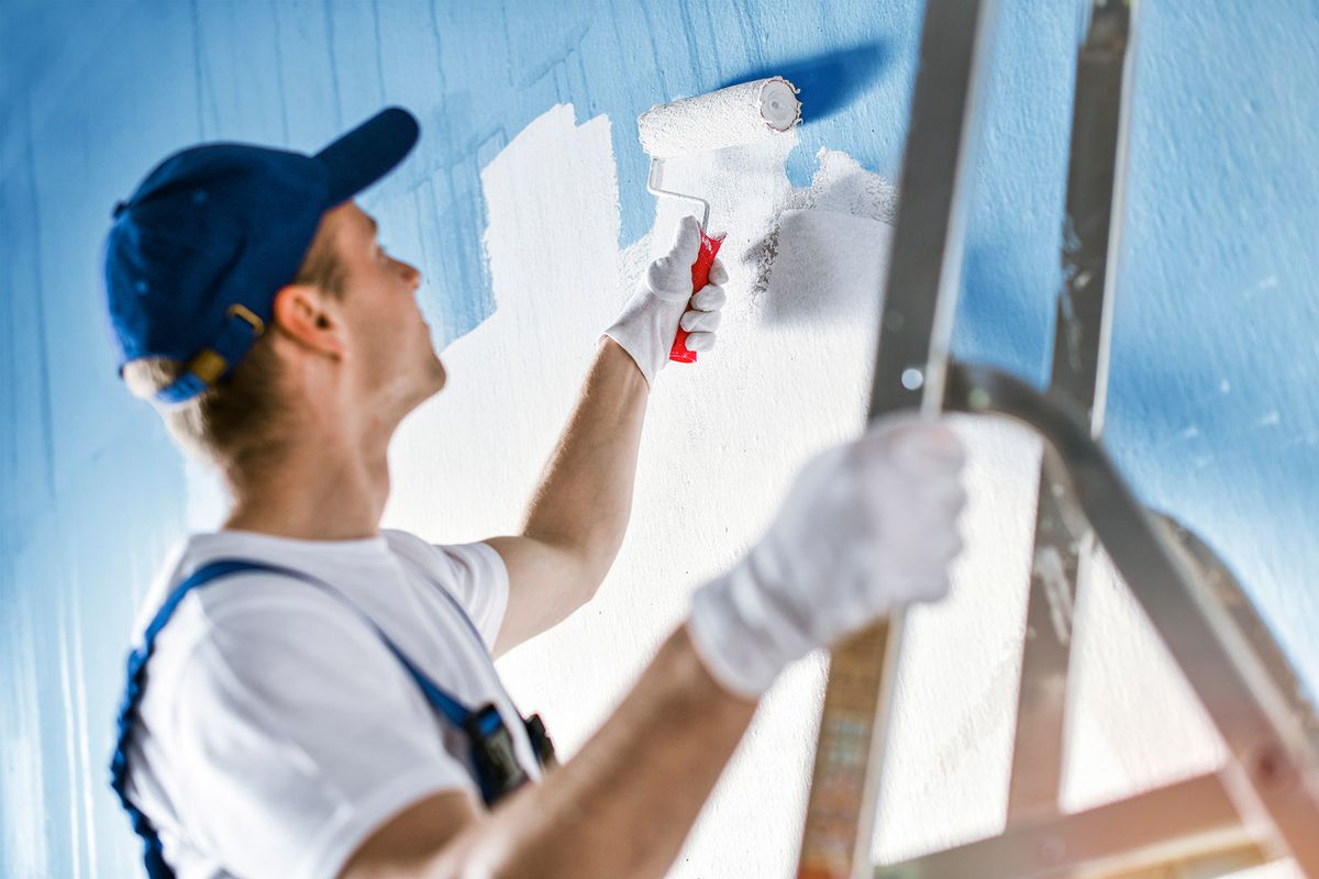 Painter,Painting,A,Wall,With,Paint,Roller.,Builder,Worker,Painting
Painter painting a wall with paint roller. Builder worker painting blue surface with white color.