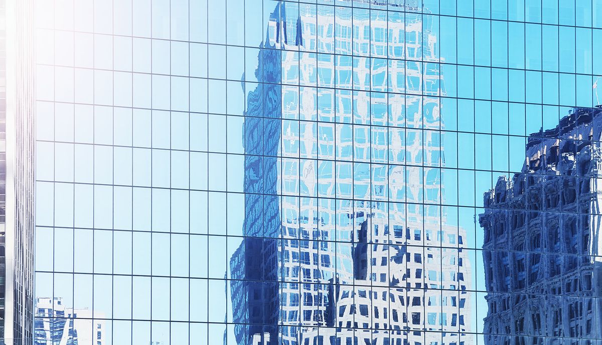 Distorted,View,Of,Buildings,Reflected,In,Windows,Of,A,Modern