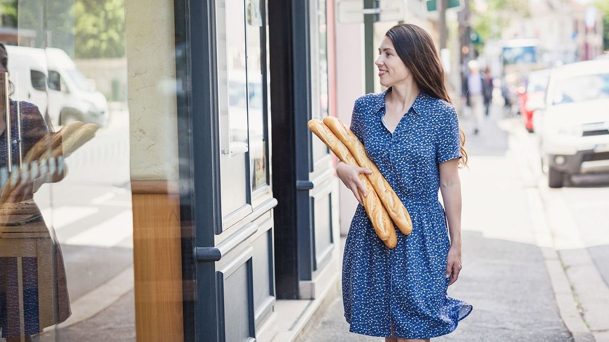 Young,Pretty,Woman,Buying,A,French,Baguette,And,Standing,On