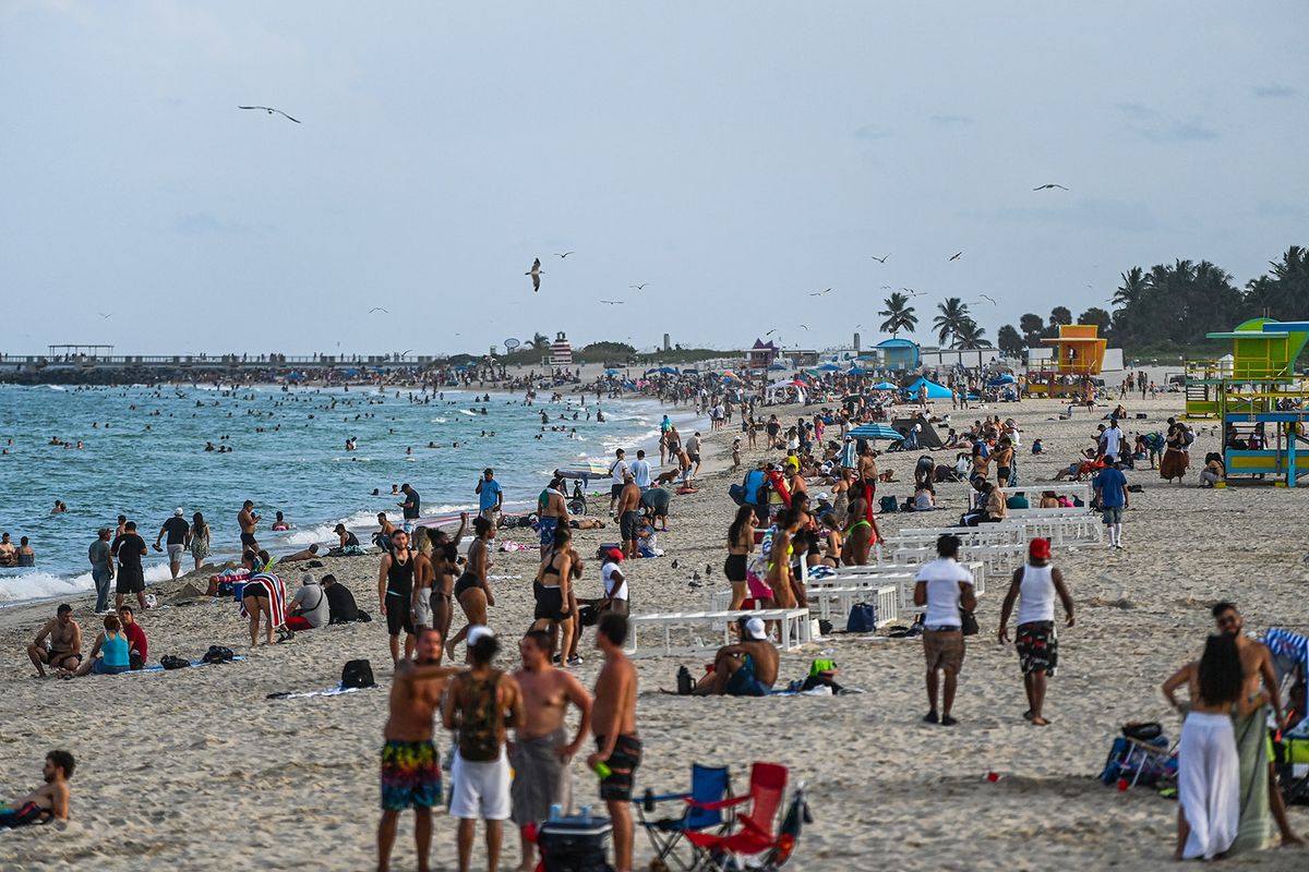 People stand on the sand in Miami Beach, Florida, on September 6, 2021, during the Labor Day holiday. (Photo by CHANDAN KHANNA / AFP)