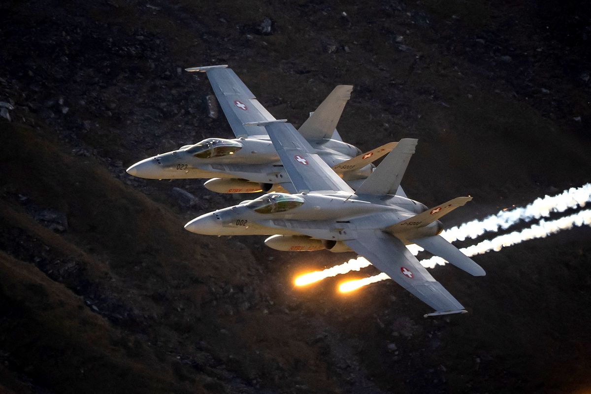 Two McDonnell Douglas F/A-18 Hornet of the Swiss Air Force perform during the annual live fire event over the Axalp in the Bernese Oberland, on October 19, 2022. At an altitude of 2,200 meters above sea level, spectators attended a unique aviation display performed at the highest air force firing range in Europe. (Photo by Fabrice COFFRINI / AFP) / “The erroneous mention[s] appearing in the metadata of this photo by Fabrice COFFRINI has been modified in AFP systems in the following manner: [October 19] instead of [October 18]. Please immediately remove the erroneous mention[s] from all your online services and delete it (them) from your servers. If you have been authorized by AFP to distribute it (them) to third parties, please ensure that the same actions are carried out by them. Failure to promptly comply with these instructions will entail liability on your part for any continued or post notification usage. Therefore we thank you very much for all your attention and prompt action. We are sorry for the inconvenience this notification may cause and remain at your disposal for any further information you may require.”