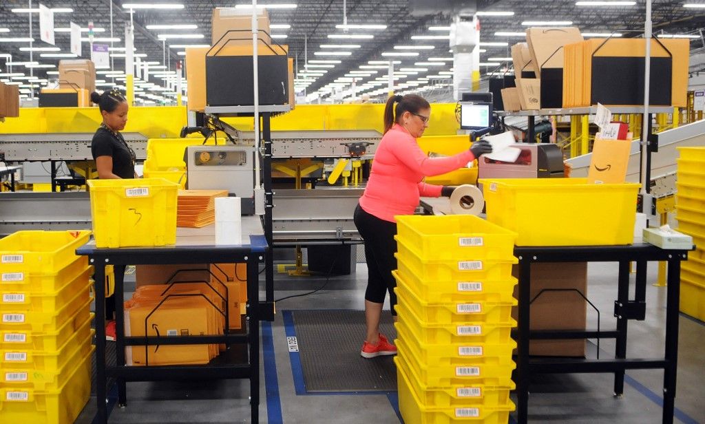 Amazon's Newest Robotics Fulfillment Center Holds Grand Opening In OrlandoAmazon associates place labels on packages at the newest Amazon Robotics fulfillment center during its first public tour on April 12, 2019 in the Lake Nona community of Orlando, Florida. The over 855,000 square foot facility opened on August 26, 2018 and employs more than 1500 full-time associates who pick, pack, and ship customer orders with the assistance of hundreds of robots which can lift as much as 750 pounds and drive 5 feet per second.  (Photo by Paul Hennessy/NurPhoto) (Photo by Paul Hennessy / NurPhoto / NurPhoto via AFP)