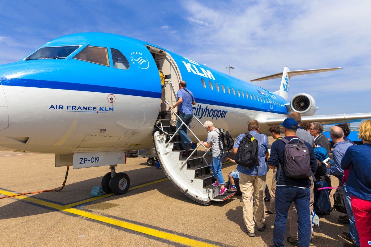 Amsterdam,-,19,July,,2014:,Travellers,To,Toulouse,In,France
AMSTERDAM - 19 JULY, 2014: Travellers to Toulouse in France are boarding an Air France KLM Cityhopper Fokker F70 at Schiphol Airport in the Netherlands.