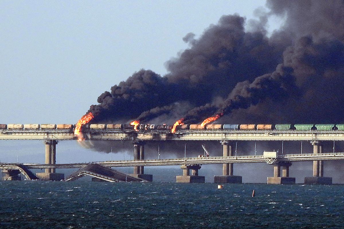 Black smoke billows from a fire on the Kerch bridge that links Crimea to Russia, after a truck exploded, near Kerch, on October 8, 2022. Moscow announced on October 8, 2022 that a truck exploded igniting a huge fire and damaging the key Kerch bridge -- built as Russia's sole land link with annexed Crimea -- and vowed to find the perpetrators, without immediately blaming Ukraine. (Photo by AFP)