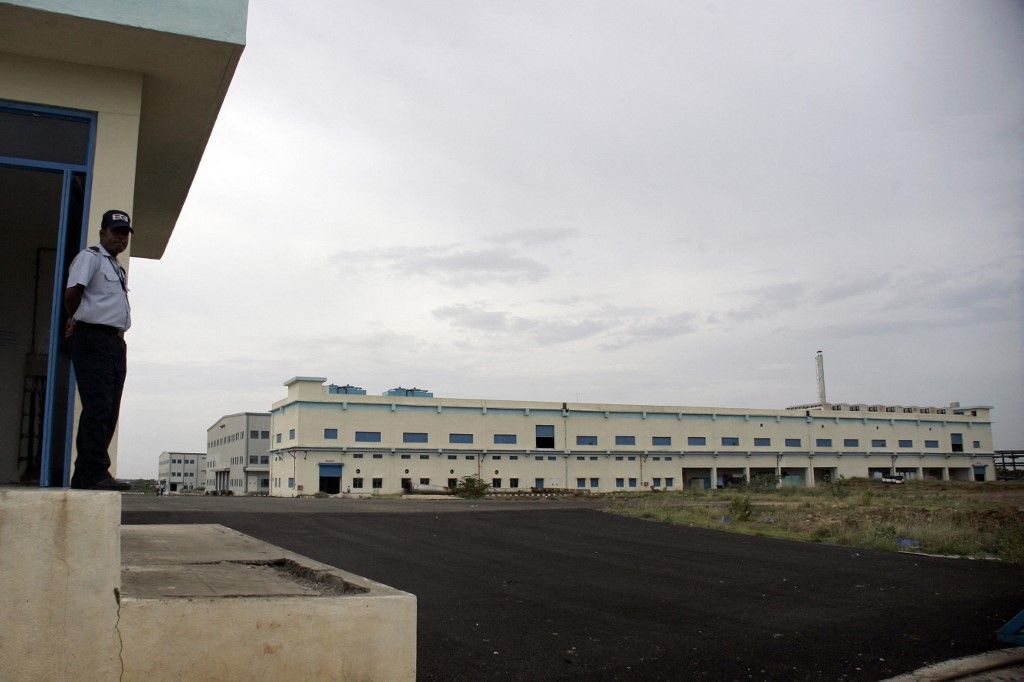 A security guard stands at the entrance of a factory operated by Taiwan-based IT giant Foxconn at Sriperumpudur, in the outskirts of Chennai, on July 27, 2010. Taiwan's troubled IT giant Foxconn has suspended operations at a factory in India after 250 workers were hospitalised in an incident thought to be linked to spraying of pesticide. Work at the facility in Chennai, southern India, was halted on July 26 and is expected to resume in about a week, Foxconn said in a statement. Foxconn, whose parent Hon Hai is a major supplier for Apple and other electronics giants, has been hit by a series of suicides at production facilities in China that have damaged the company's reputation. AFP PHOTO/STR (Photo by STRDEL / AFP)