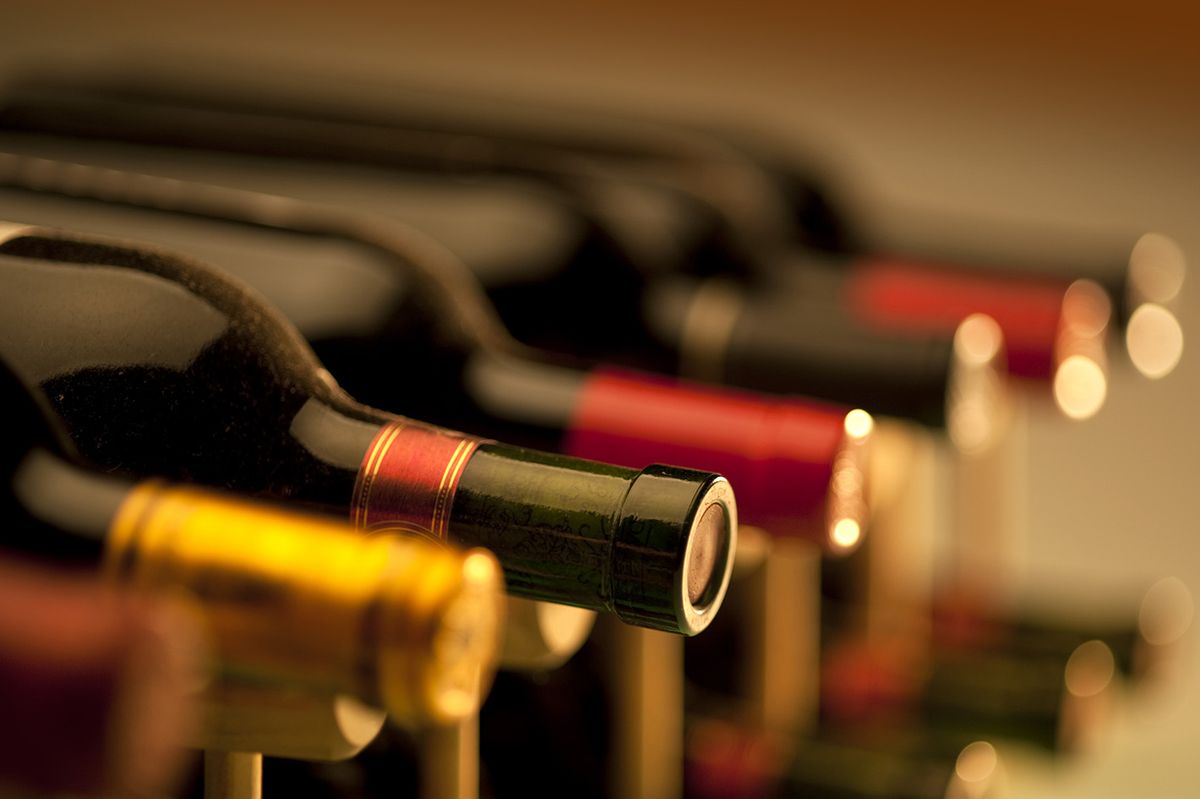 Red,Wine,Bottles,Stacked,On,Wooden,Racks,Shot,With,Limited