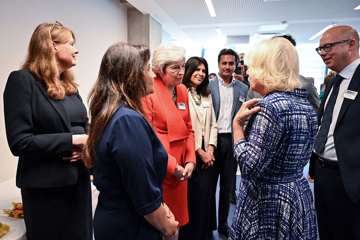 Britain's Queen Camilla (2nd R) speaks with Britain's MP for the Conservative Party and former Prime Minister Theresa May (L) during a reception following her visit of a laboratory that specialises in developing new approaches to study multiple autoimmune diseases at The Royal Free Hospital, in Hampstead, northwest London, on June 29, 2023. (Photo by JUSTIN TALLIS / POOL / AFP)