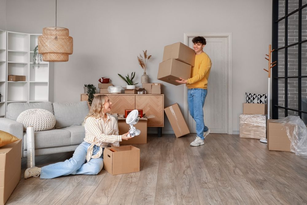 Young,Couple,Packing,Things,In,Room,On,Moving,Day