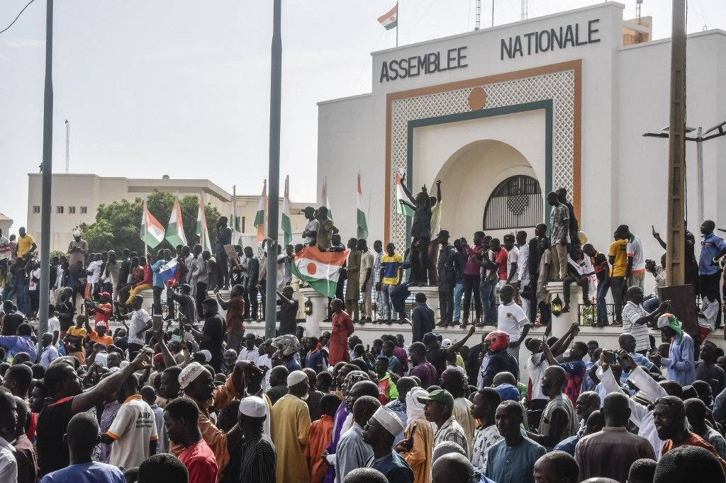 Supporters wave Nigerien's flags as they rally in support of Niger's junta in front of the National Assembly in Niamey on July 30, 2023. Niger's junta on Sunday said ECOWAS could stage an imminent military intervention in the capital Niamey as the regional body meets for an "extraordinary summit" on the coup-hit country, with sanctions a possibility. The country's elected president Mohamed Bazoum has been held by the military for four days, and General Abdourahamane Tiani, the chief of the powerful presidential guard, has declared himself leader. (Photo by AFP)