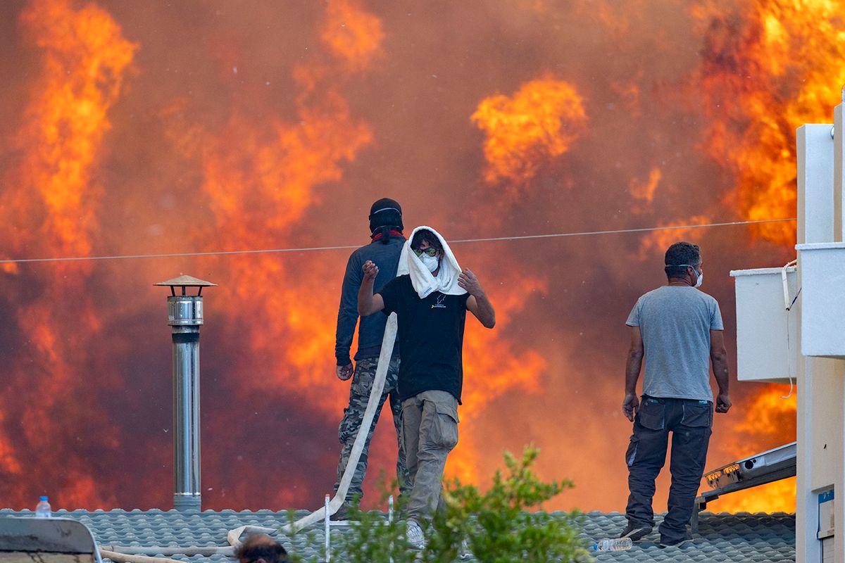 Forest fires in Greece - Rhodesurn:newsml:dpa.com:20090101:230725-99-52935225 July 2023, Greece, Gennadi: Towards evening flames reach the village of Gennadi, residents stand on their roofs in front of huge flames and try to save their houses with water hoses. Heat on the Mediterranean - thousands of people flee forest fires on Rhodes. In Greece, forest fires are raging in numerous regions. Popular vacation resorts such as the islands of Rhodes and Corfu are also affected. Photo: Christoph Reichwein/dpa Forest Fires In Greece - Rhodes  wildfire, wildfires July   2023