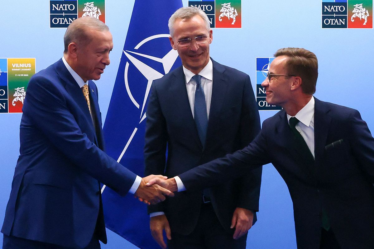 Turkish President Tayyip Erdogan (L) and Swedish Prime Minister Ulf Kristersson shake hands in front of NATO Secretary-General Jens Stoltenberg prior to their meeting, on the eve of a NATO summit, in Vilnius on July 10, 2023.