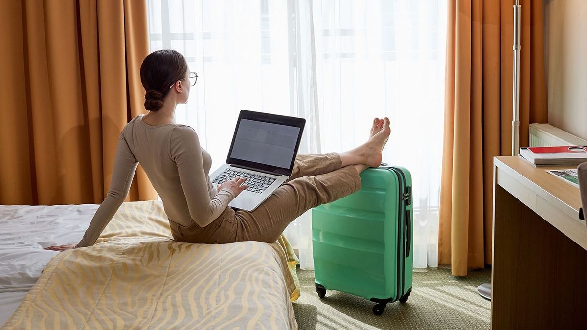 Young,Caucasian,Woman,Sitting,In,Hotel,Room,And,Working,On