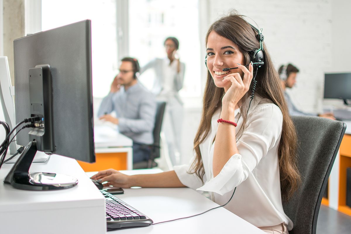 Young,Friendly,Operator,Woman,Agent,With,Headsets,Working,In,A