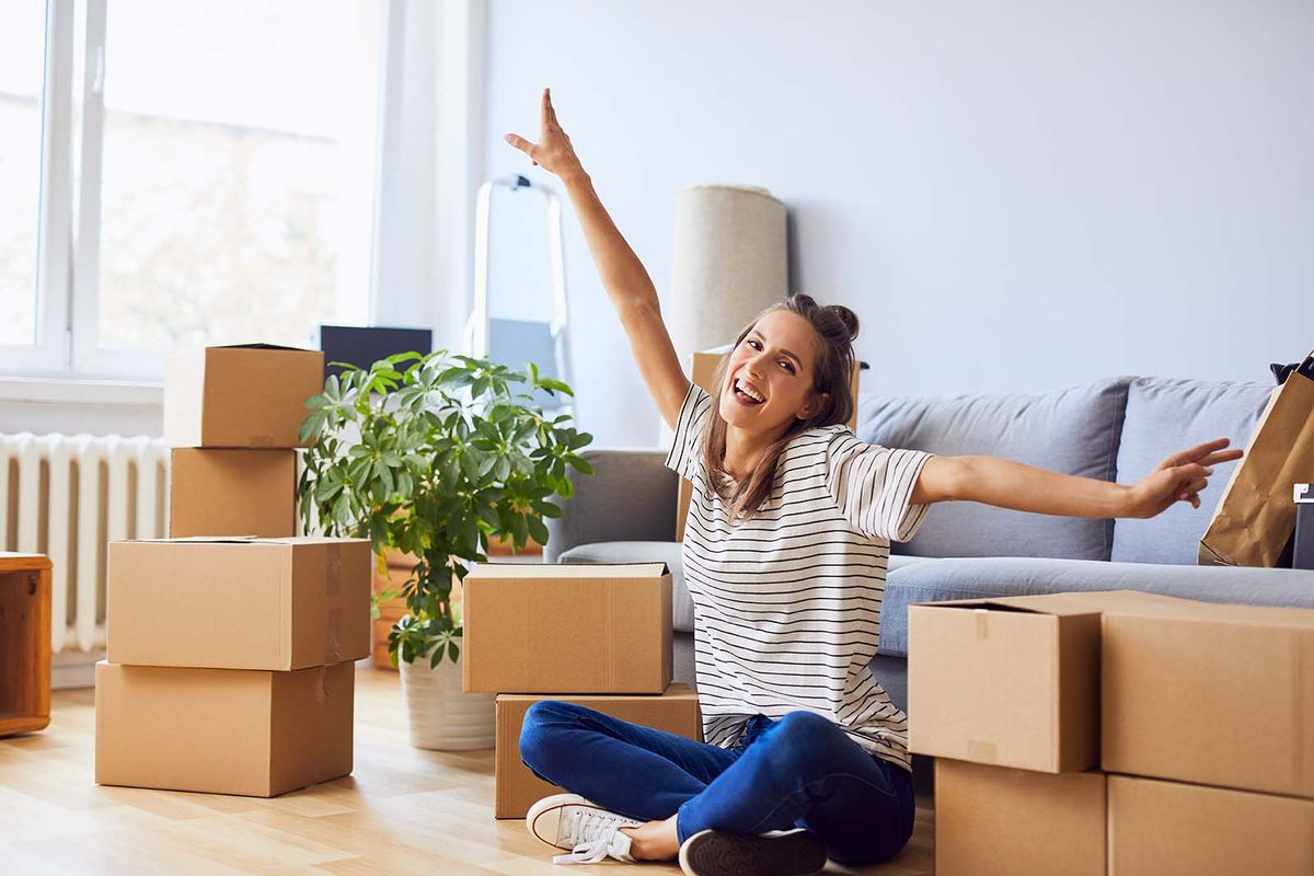 Young,Woman,Sitting,In,New,Apartment,And,Raising,Arms,In
Young woman sitting in new apartment and raising arms in joy after moving in