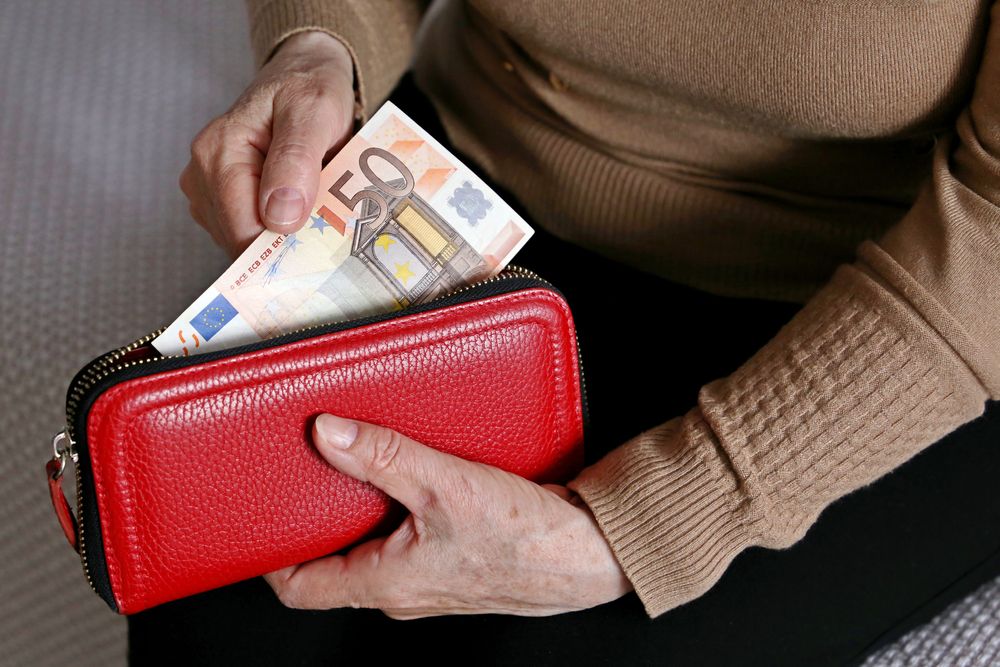 Elderly,Woman,Takes,Out,A,Euro,Note,From,Her,Wallet.