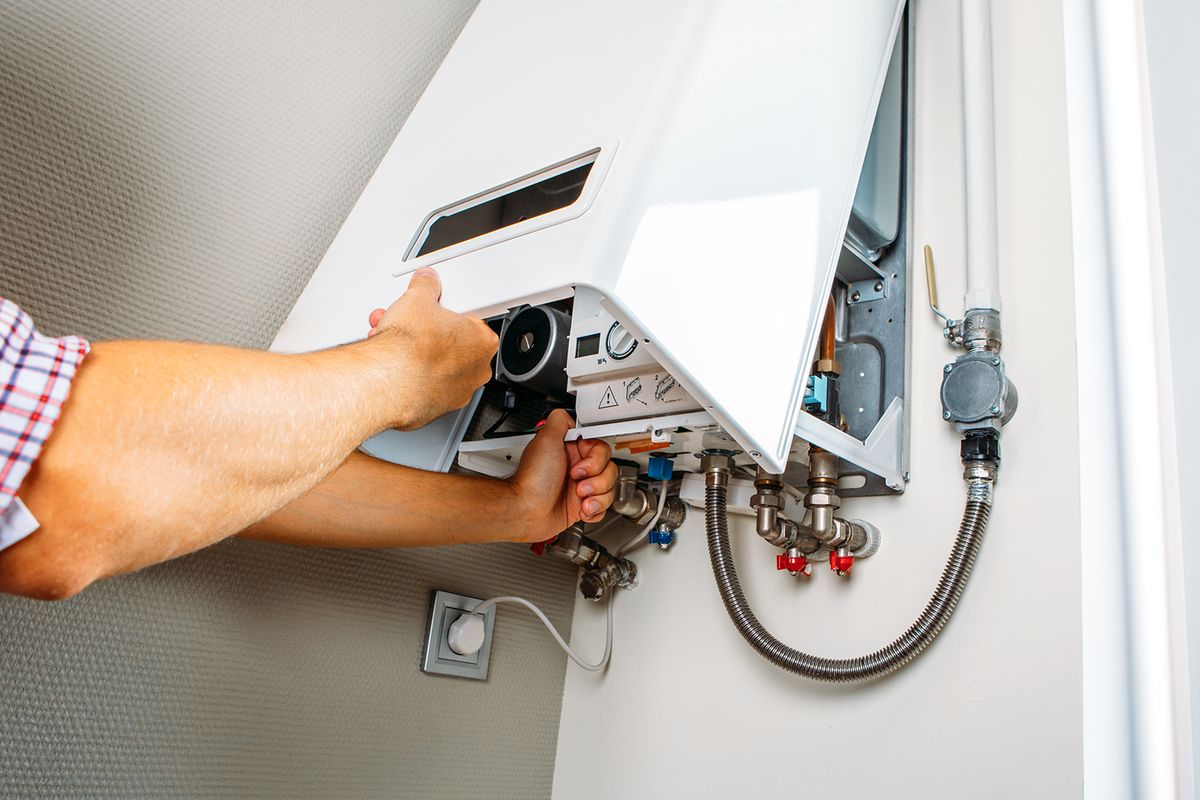 Plumber,Attaches,Trying,To,Fix,The,Problem,With,The,Residential
Plumber attaches Trying To Fix the Problem with the Residential Heating Equipment. Repair of a gas boiler