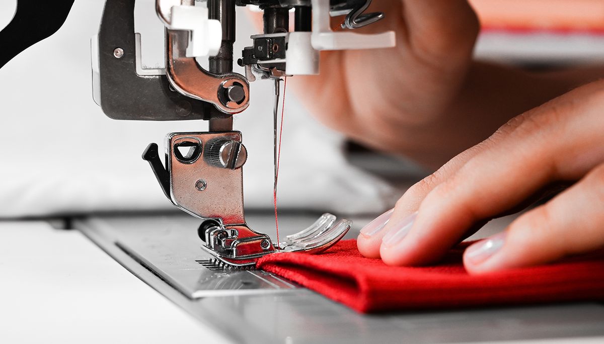 Woman's,Hands,With,Red,Fabrics,At,Sewing,Machine.,Self,Made