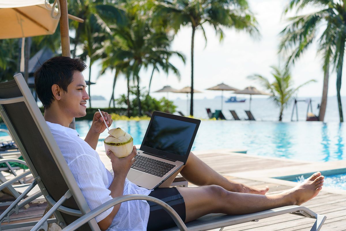Asian,Man,Drinking,Coconut,Water,While,He,Is,Working,On
Asian man drinking coconut water while he is working on his laptop on a chairnear pool at resort hotel on summer vacation holiday.