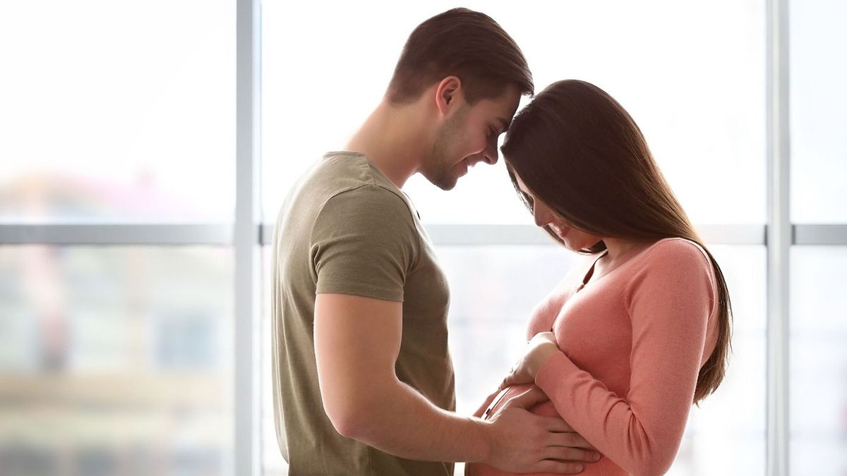 Pregnant,Woman,With,Husband,In,Front,Of,The,Window