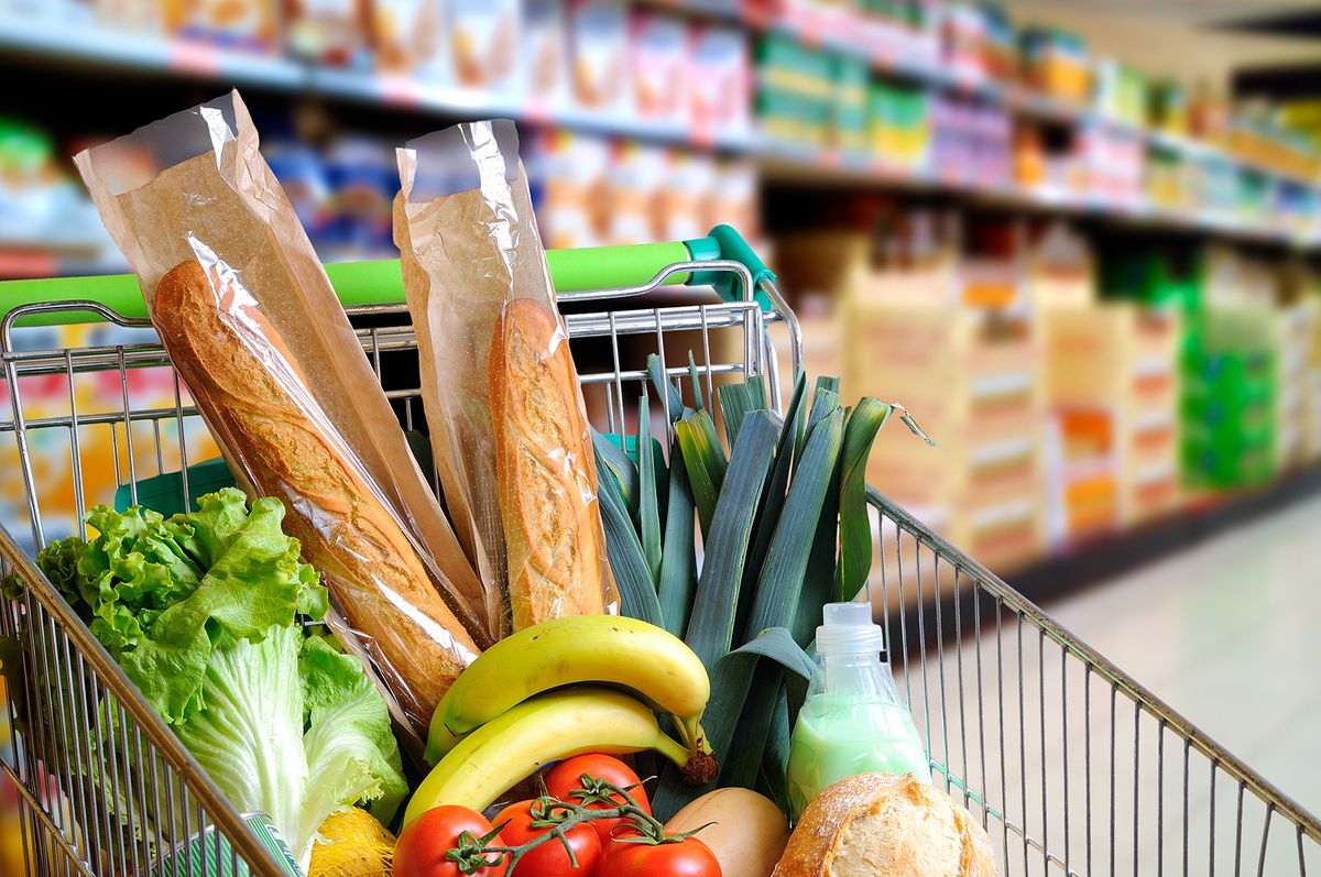 Shopping,Cart,Full,Of,Food,In,The,Supermarket,Aisle.,High,Shopping cart full of food in the supermarket aisle. High internal view. Horizontal composition