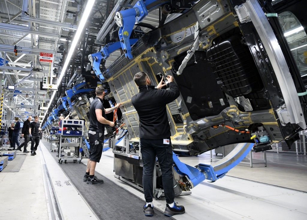 Employees of German car maker Mercedes-Benz work on the bottom side of an EQS passenger car at the 'Factory 56', a completely digitized assembly line, at the Mercedes-Benz manufacturing plant in Sindelfingen, southwestern Germany, on February 13, 2023. Mercedes-Benz will present their 2022 annual results on February 17, 2023. (Photo by THOMAS KIENZLE / AFP)