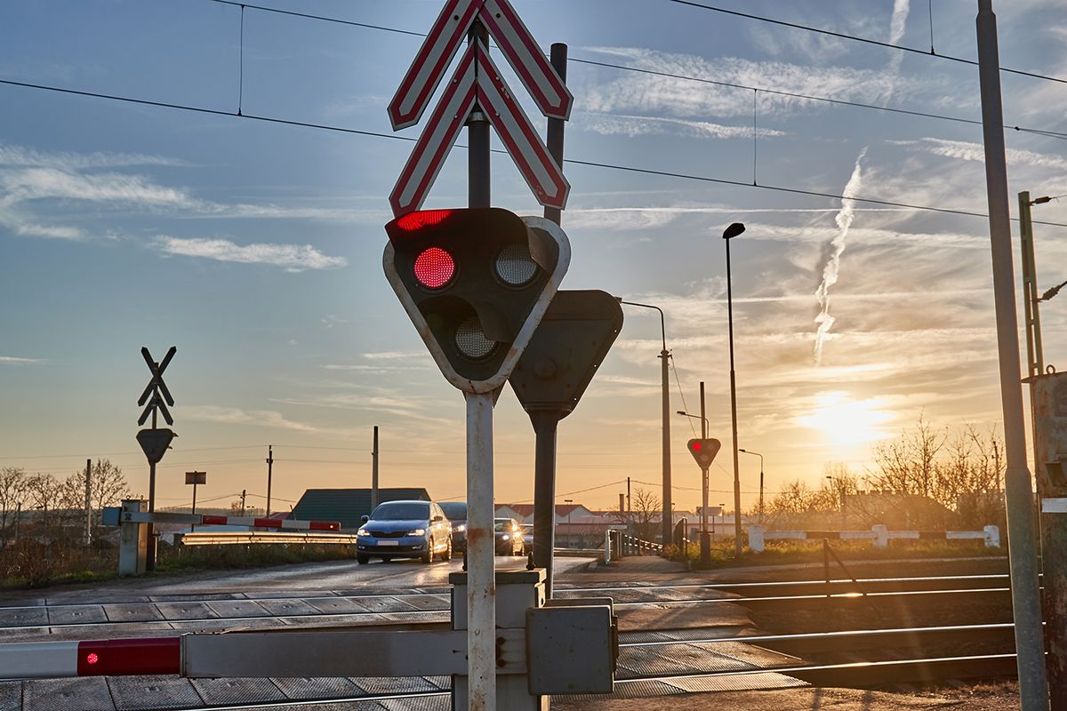 Red,Lights,At,A,Railway,Crossing,,Cars,Waiting,For,The