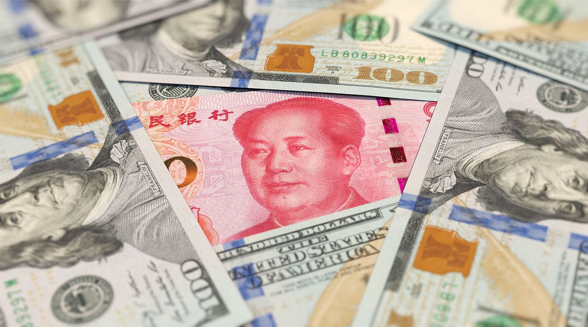 100 yuan banknote among 100 US dollar banknotes 