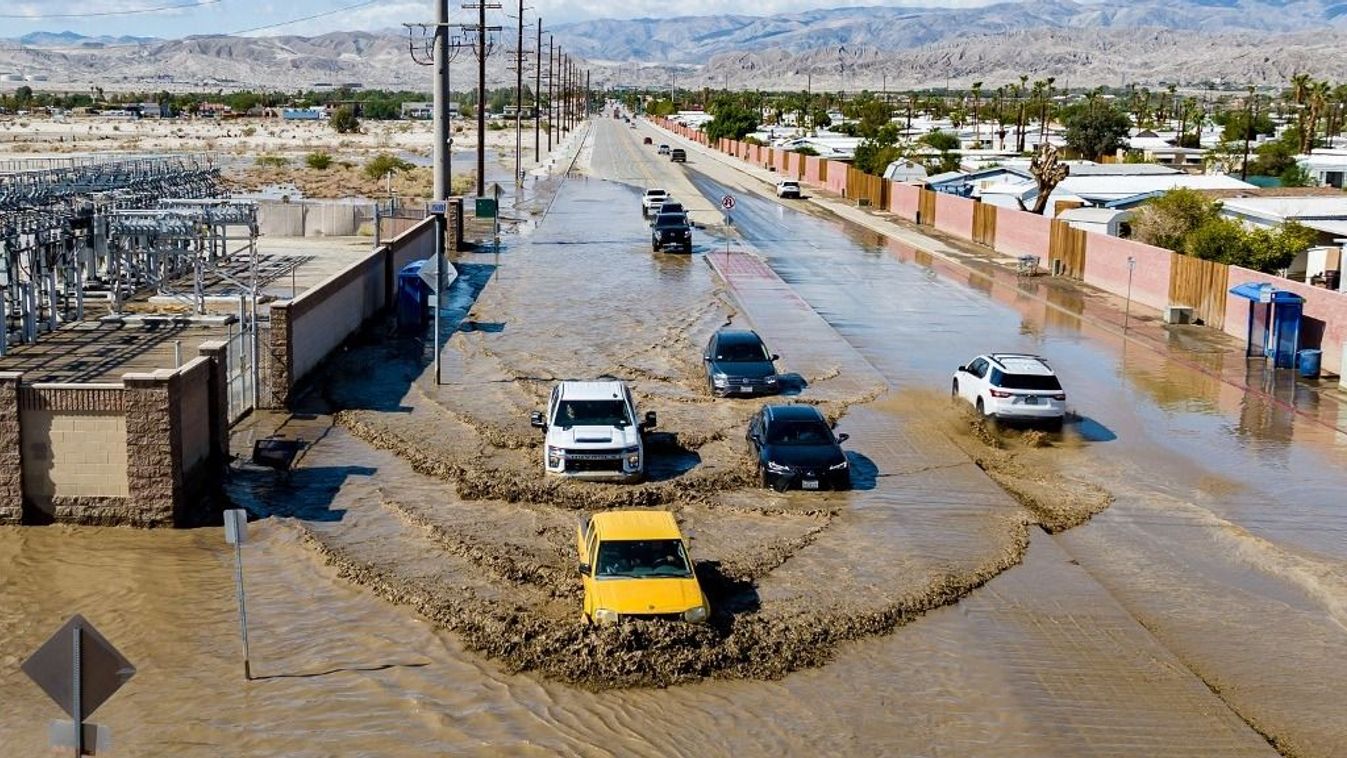 In this aerial picture taken on August 21, 2023 vehicles drive through floodwaters following heavy rains from Tropical Storm Hilary in Thousand Palms, California. Tropical Storm Hilary drenched Southern California with record rainfall, shutting down schools, roads and businesses before edging in on Nevada on August 21, 2023. California Governor Gavin Newsom had declared a state of emergency over much of the typically dry area, where flash flood warnings remained in effect until this morning. (Photo by JOSH EDELSON / AFP)